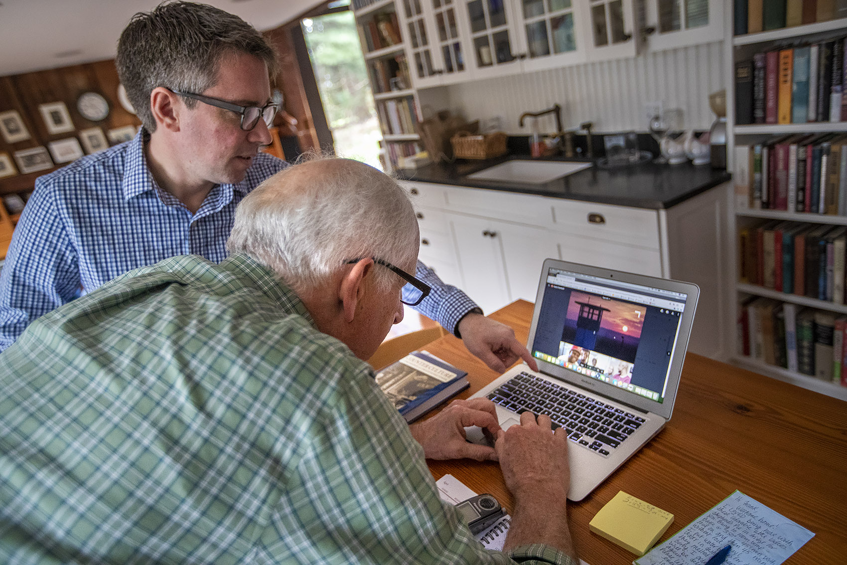 Andrew Kukura and Frank Phillips look at the latest version of the trailer for “The Angola Project,” a film which Phillips’ late wife Jenny began before her unexpected death last summer. (Jesse Costa/WBUR)