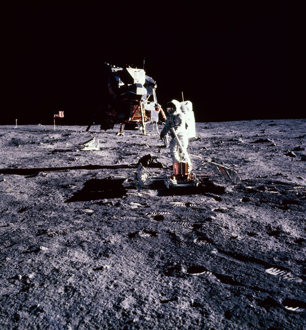Astronaut Buzz Aldrin deploys a scientific experiment on the lunar surface a few yards away from the lunar module. (NASA)