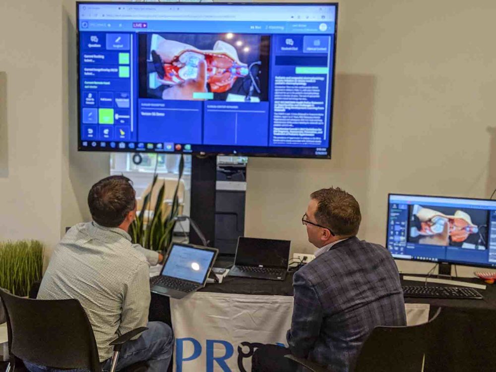 Boston telemedicine firm Proximie hopes 5G speed can help doctors guide surgeries in real time from remote locations. Proximie's North America market development manager, Wayne Kesti, right, demonstrates the company's software on a 5G cellular network at the Verizon Alley in Cambridge. (Courtesy of Verizon)