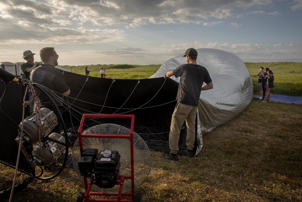 Balloon pilot Andy Richardson and his crew begin the process of inflating the New Horizon balloon. (Robin Lubbock/WBUR)