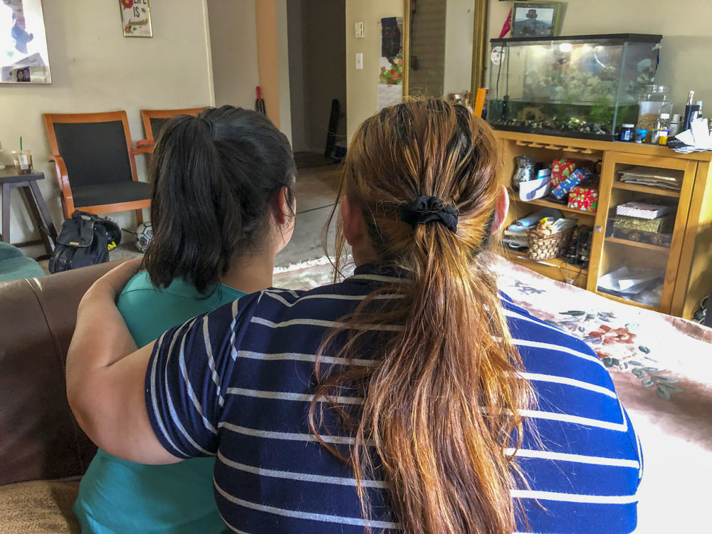 H holds her daughter M inside her home in Framingham, Mass. (Shannon Dooling/WBUR)