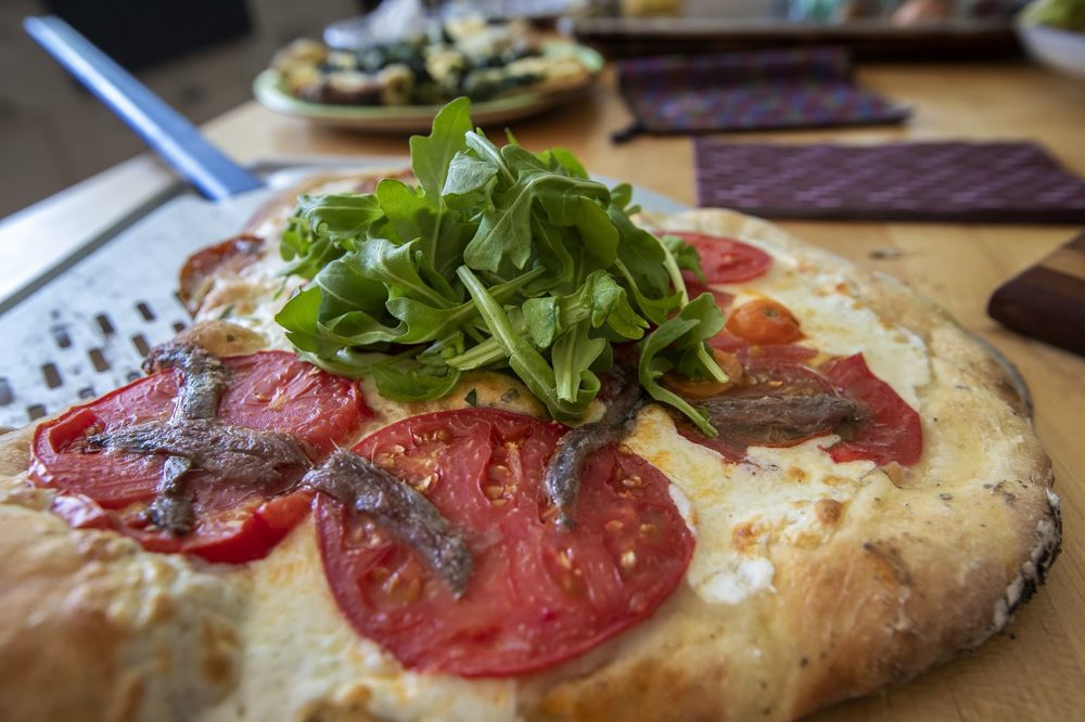 Tomato, mozzarella, arugula and anchovy pizza. (Jesse Costa/WBUR)