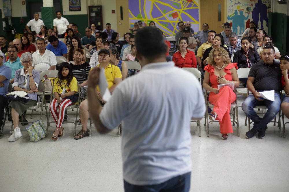 Jose Palma, foreground, head of the Massachusetts Temporary Protected Status Committee, address a TPS meeting in Somerville, Mass. TPS is a program that offers temporary legal status to some immigrants in the U.S. who can't return to their country because of war or natural disasters. (Steven Senne/AP)