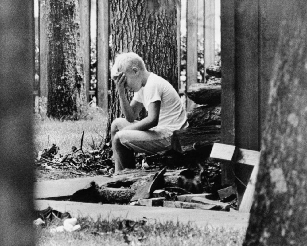 On July 20, 1969, Andy Aldrin, 10, sits in the backyard of his home in Houston while other members of his family listen to the reports of the progress of the lunar module carrying his father, Col. Buzz Aldrin, and fellow astronaut Neil Armstrong to a landing on the moon. (AP)