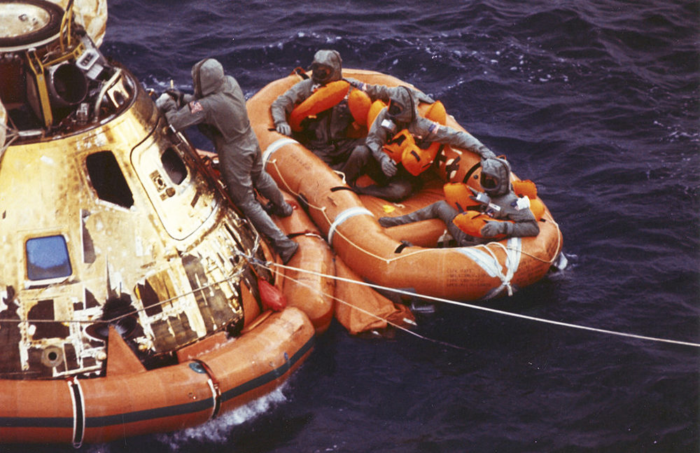On July 24, 1969, Lt. Clancy Hatleberg closes the Apollo 11 spacecraft hatch as astronauts Neil Armstrong, Michael Collins and Buzz Aldrin await helicopter pickup from their life raft after splashdown in the Pacific Ocean. (Milt Putnam/U.S. Navy via AP)