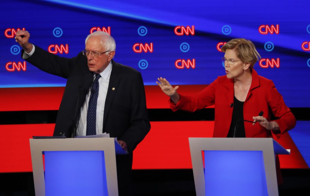 Sen. Bernie Sanders, I-Vt., and Sen. Elizabeth Warren, D-Mass., talk during in the first of two Democratic presidential primary debates hosted by CNN Tuesday, July 30, 2019, in the Fox Theatre in Detroit. (Paul Sancya/AP)