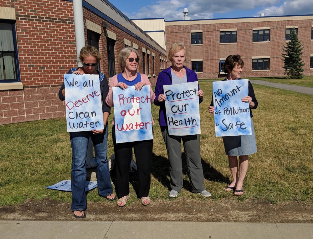 New Hampshire PFAS activists hold signs outside an Environmental Protection Agency forum on the issue last summer in Exeter. (Annie Ropeik/NHPR)