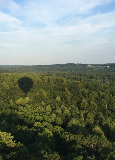 The shadow of Doug Aitken's hot air balloon is seen on the forests around Harvard, Massachusetts, during a test flight earlier this month. (Amelia Mason/WBUR)