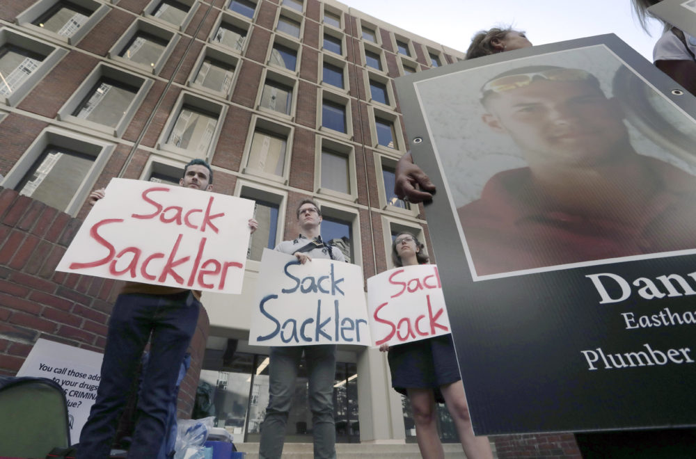 Protesters gather outside Suffolk Superior Court in Boston on Friday, where a judge was to hear arguments in Massachusetts' lawsuit against Purdue Pharma. (Charles Krupa/AP)