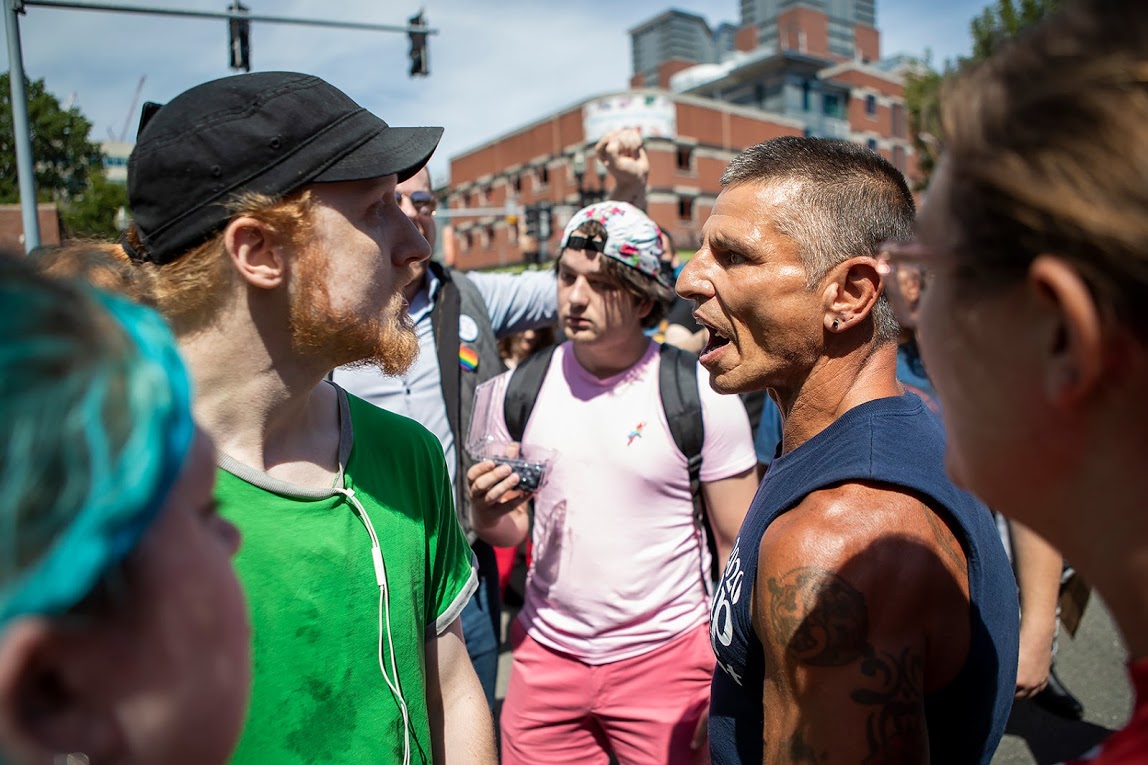 Tempers flare between a counter-protester, left, and a parade participant at City Hall Plaza. (Jesse Costa/WBUR)