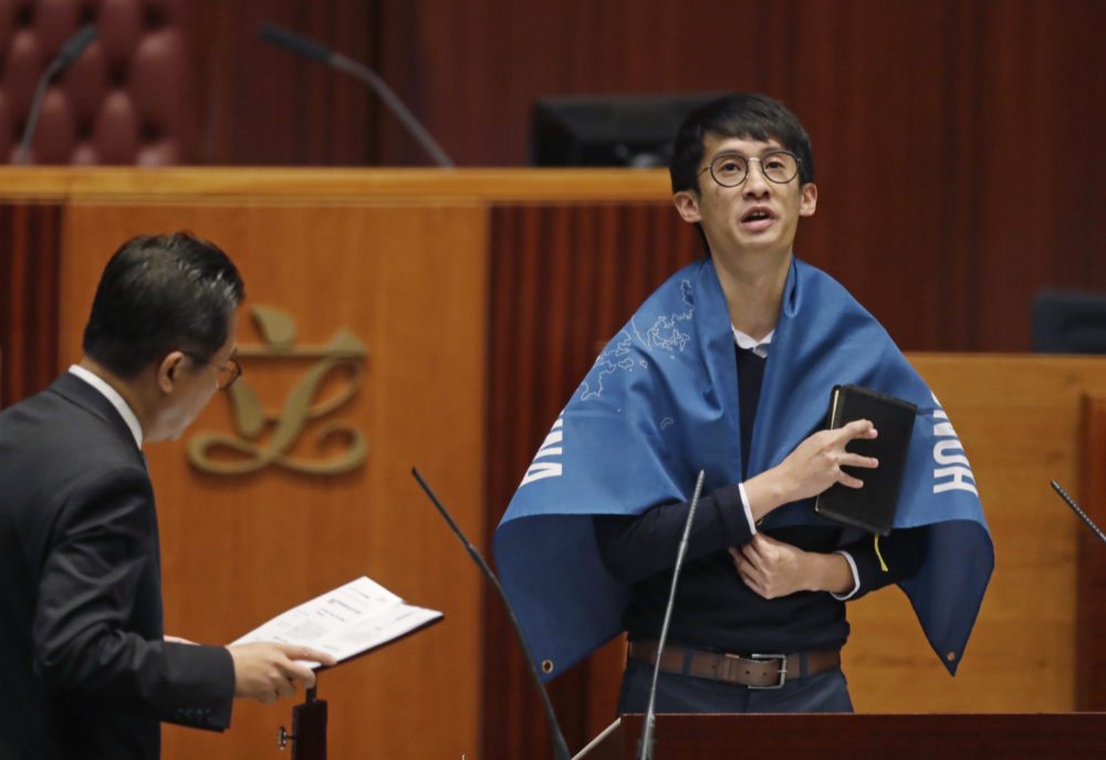 Sixtus Leung of Youngspiration wears a banner with words reading “Hong Kong is not China” as he takes oath in the new legislature Council in Hong Kong in 2016. (Kin Cheung/AP)
