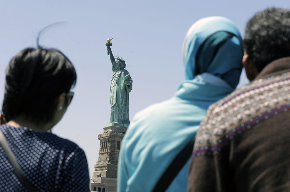In this May 7, 2015, file photo, people look at the Statue of Liberty from a ferry boat in Jersey City, N.J. (Mel Evans/AP)