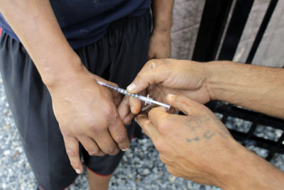 In this 2017 file photo, an unidentified heroin user is injected by another man on the street in Boston. (Steven Senne/AP)