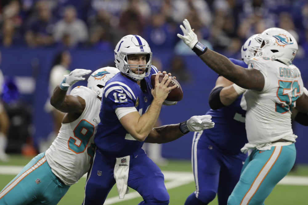 Colts quarterback Andrew Luck (12) is hit by Miami Dolphins defensive end Robert Quinn (94) during a game on Nov. 25, 2018. (Darron Cummings/AP)