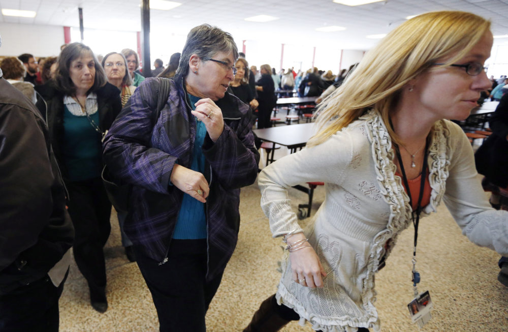 In this March 15, 2013, file photo, participants rush out of the cafeteria after hearing gun shots during a lockdown exercise at Milford High School in Milford, Mass. (Michael Dwyer/AP)