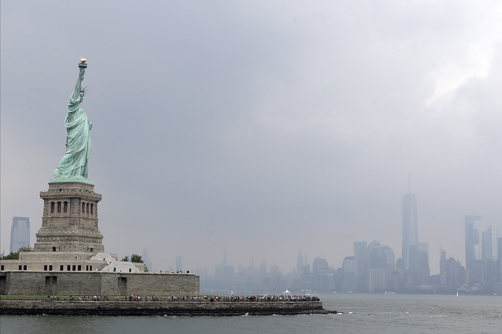 This photo shows the Statue of Liberty on a stormy afternoon in New York on Wednesday, Aug. 14, 2019. A biographer of poet Emma Lazarus on Wednesday challenged a comment by the acting director of U.S. Citizenship and Immigration Services, explaining that Lazarus' words were her way of urging Americans "to embrace the poor and destitute of all places and origins." (Kathy Willens/AP)