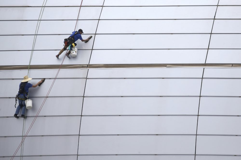In this July 31, 2019, file photo workers clean the outside facade of State Farm Stadium in Glendale, Ariz. The shareholder comes first has for years been the mantra of the Business Roundtable, a group representing the most powerful CEOs in America. The group on Monday, Aug. 19, released a new mission statement that implies a foundational shift; a step back from shareholder primacy. (Ross D. Franklin/AP)