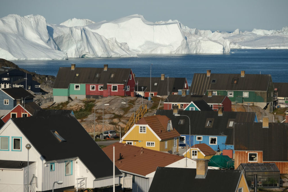 Icebergs floating at the mouth of the Ilulissat Icefjord loom behind the town center on July 30, 2019 in Ilulissat, Greenland. (Sean Gallup/Getty Images)