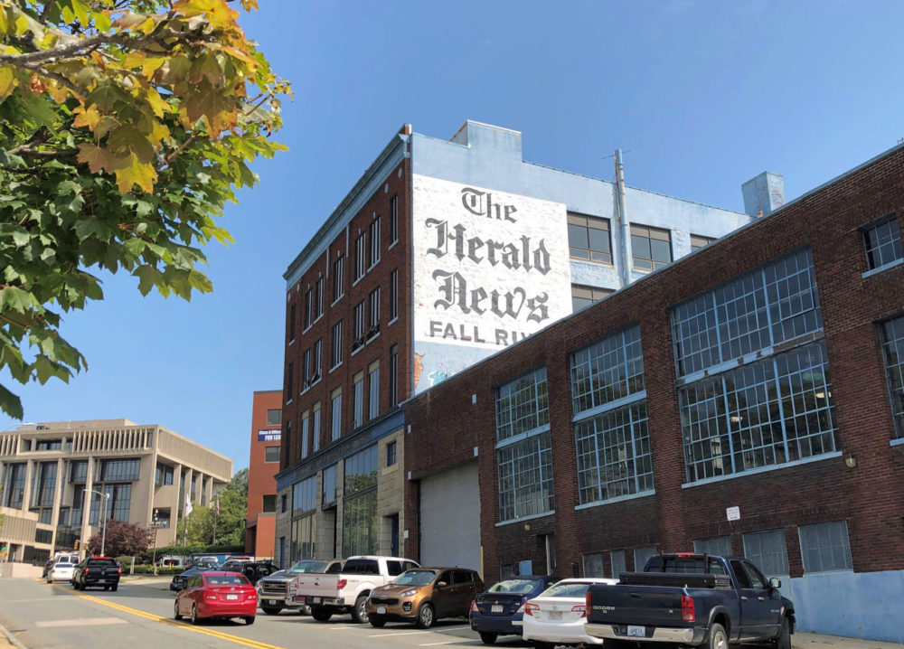 The Herald News' proximity to Fall River Government Center, left, makes it easy for reporters to keep an eye on public officials. But recent cuts at the GateHouse-owned daily have left a newsroom staff in the single digits. (Callum Borchers/WBUR)