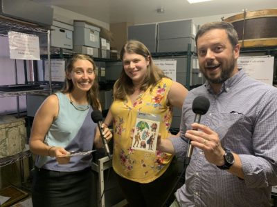 Amory (left) Stacen Goldman (center) and Ben (right), with the Land of Ta sticker sheet in the Framingham History Center's Dennison collection (Ben Brock Johnson/WBUR)