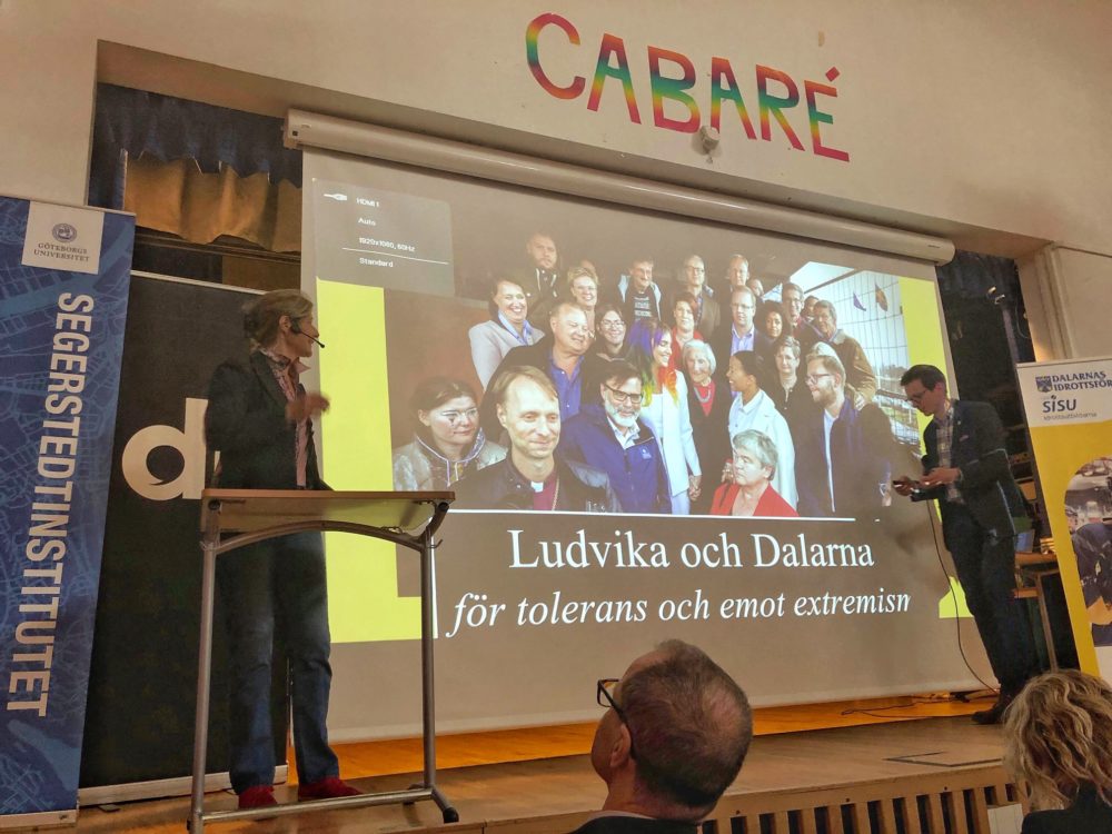 The author, left, speaks to residents of Ludvika, Sweden on May 1, 2019. In English, the slide reads: ""Ludvika and Dalarna for tolerance and against racism."  (Courtesy)