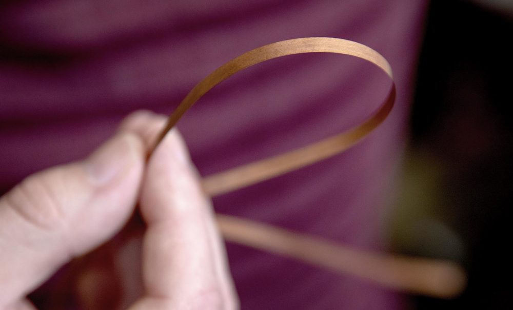 Bob Mumgaard holds a strip of super conducting tape. (Robin Lubbock/WBUR)