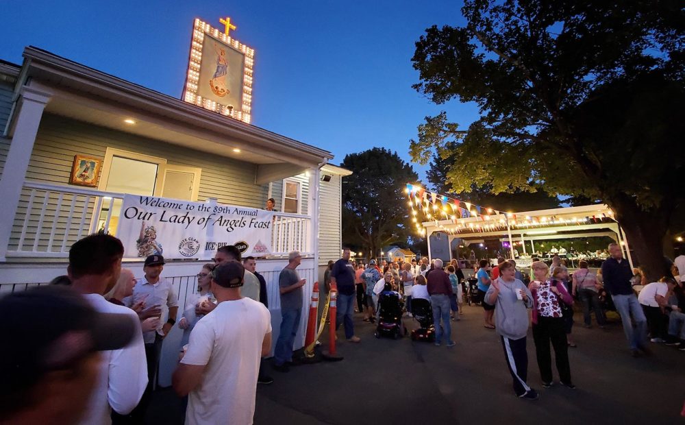 Residents gather in the twilight for Fairhaven’s Little Feast. (Angus Chen/WBUR)