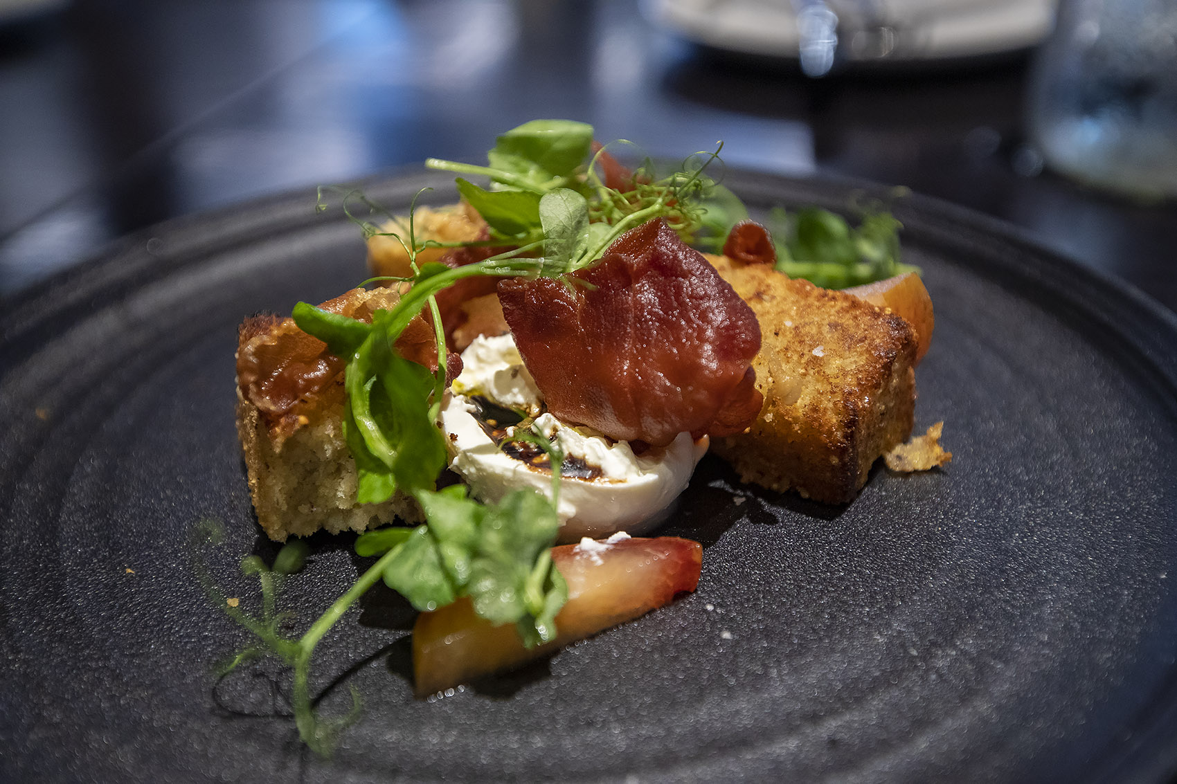 Burrata with pluots, Grilled Plimoth Cornbread, Crispy Prosciutto, and pea shoots at Trillium Brewing Fort Point. (Jesse Costa/WBUR)