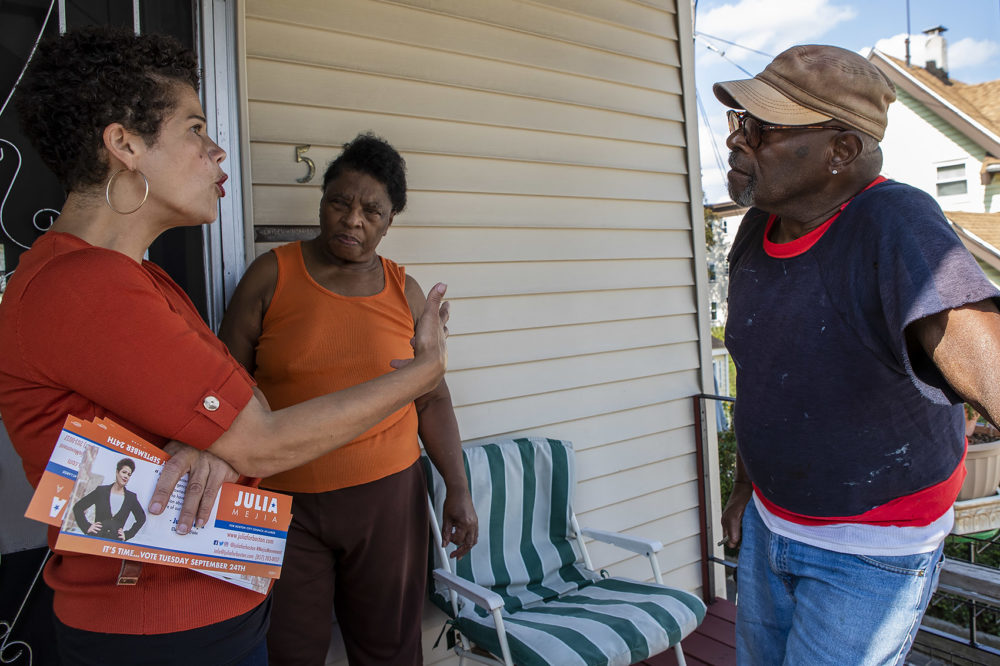 Julia Mejia, left, speaks with Carol and James Dryden about issues that concern them. (Jesse Costa/WBUR)