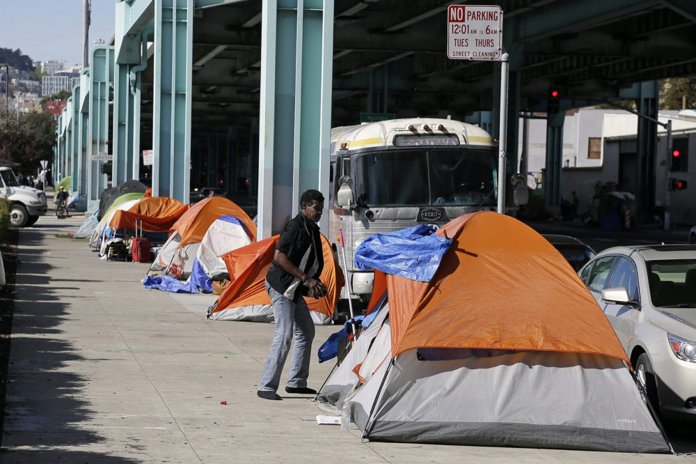 In this Feb. 23, 2016 file photo, a man stands outside his tent on Division Street in San Francisco. (Eric Risberg, File/AP)
