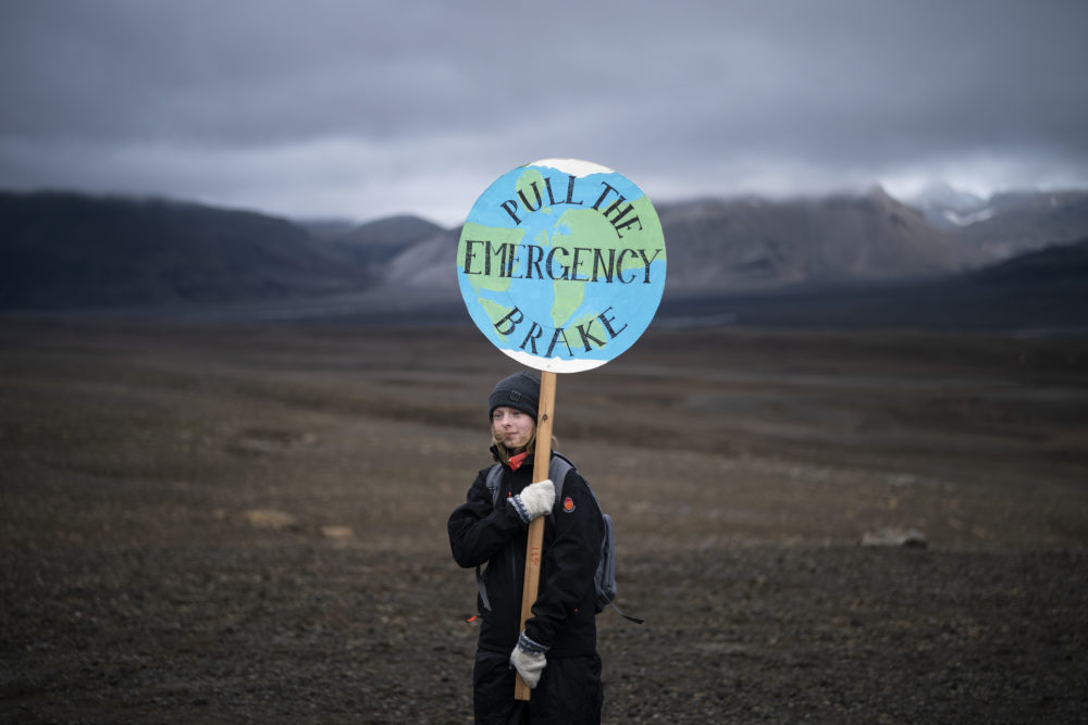 A girl holds a sign as she attends a ceremony in the area which once was the Okjokull glacier, in Iceland, Sunday, Aug. 18, 2019. With poetry, moments of silence and political speeches about the urgent need to fight climate change, Icelandic officials, activists and others bade goodbye to the first Icelandic glacier to disappear. (Felipe Dana/AP)