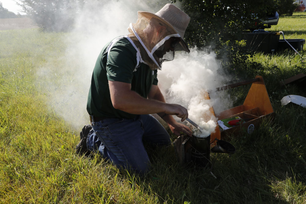 Adam Ingrao, an agricultural entomologist and military veteran who runs the Heroes to Hives program, prepares a bee smoker at the Henry Ford farm in Superior Township, Mich. (AP Photo/Carlos Osorio)