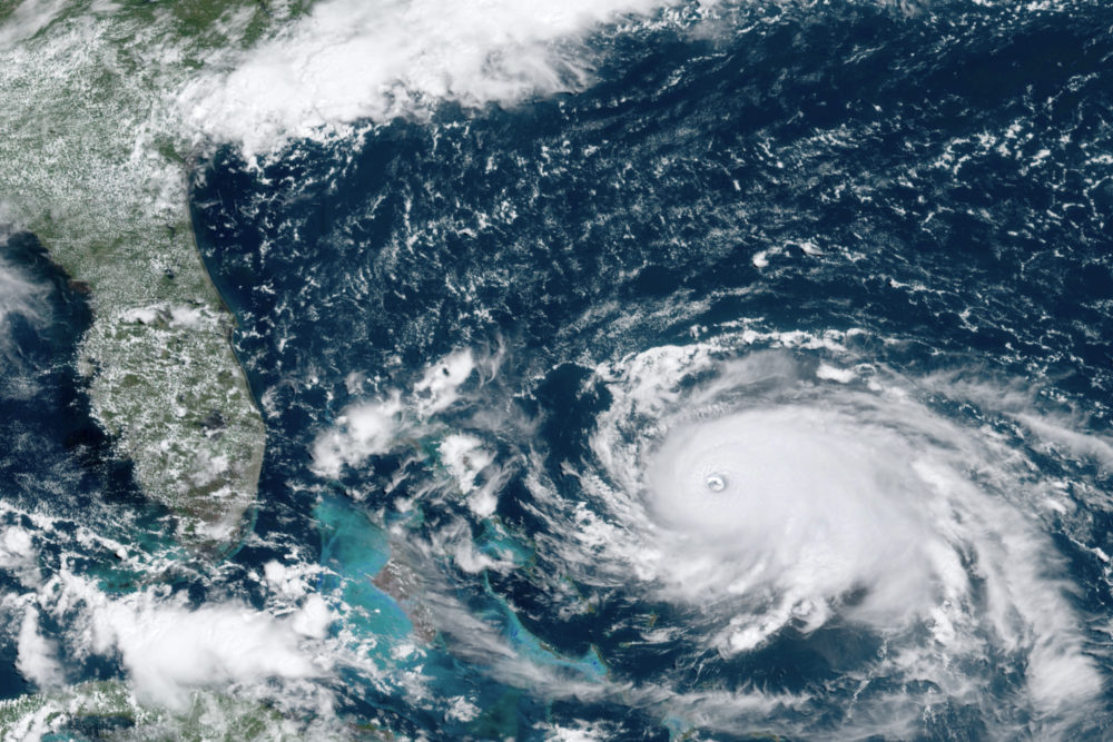 This GOES-16 satellite image taken Saturday, Aug. 31, 2019, at 16:00 and provided by National Oceanic and Atmospheric Administration shows Hurricane Dorian, right, churning over the Atlantic Ocean. (NOAA via AP)