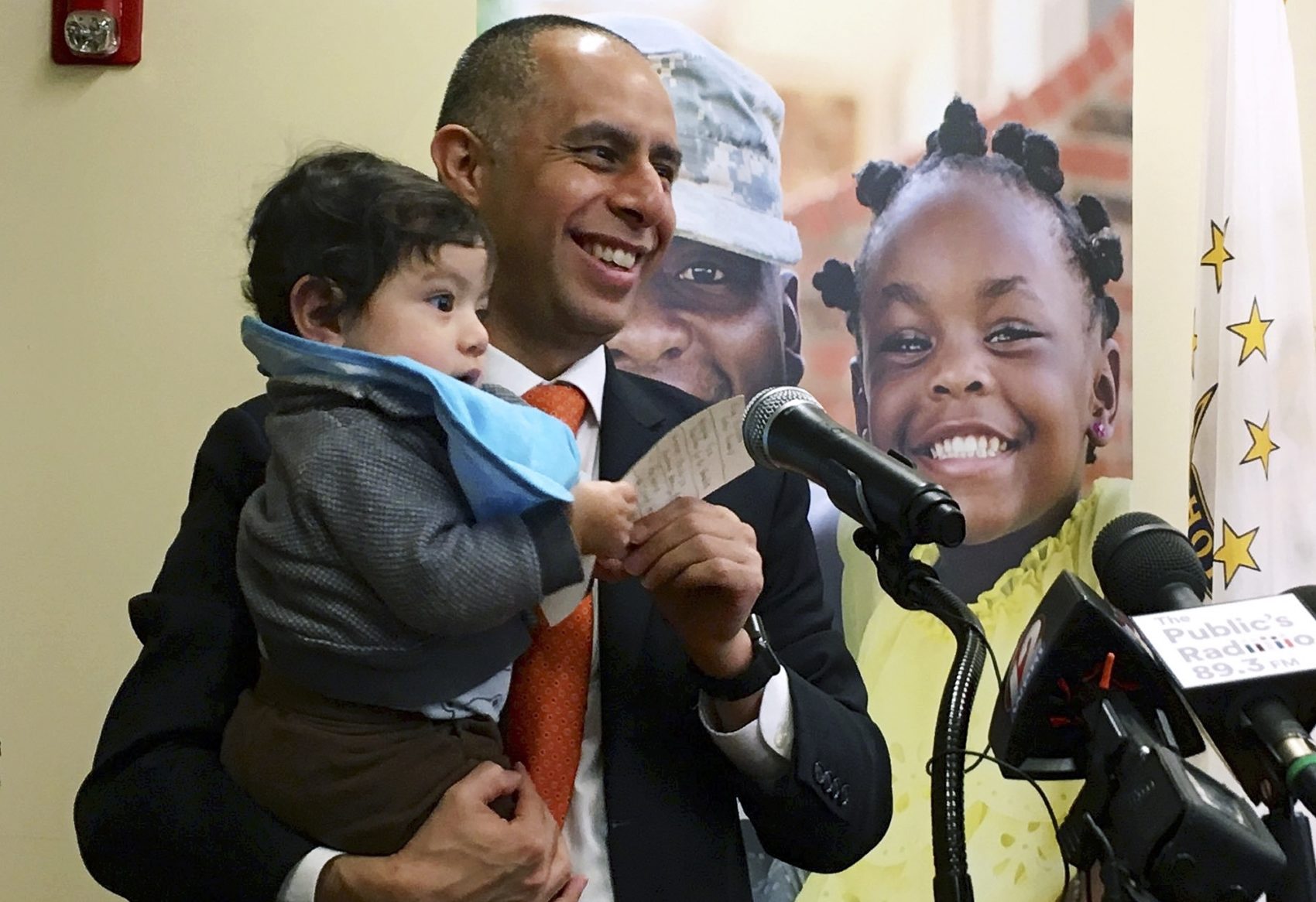 Mayor Jorge Elorza holds his son Omar during a news conference in Providence, R.I. (Steve Klamkin/WPRO News via AP)