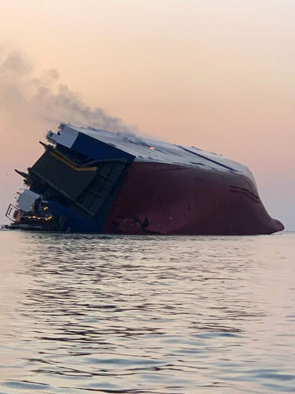 Coast Guard crews and port partners respond to an overturned cargo vessel with a fire on board Sunday, Sept. 8, 2019, in St. Simons Sound, Ga. (U.S. Coast Guard via AP)