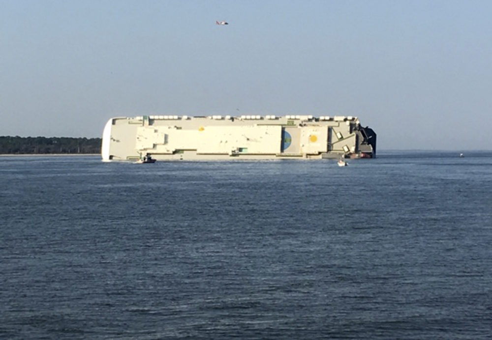 A capsized cargo ship is seen near a port on the Georgia coast, Sunday, Sept. 8, 2019. Rescuers were searching Sunday for multiple crew members of the ship that overturned and caught fire in St. Simons Sound, Ga. (Tara Jones via AP)