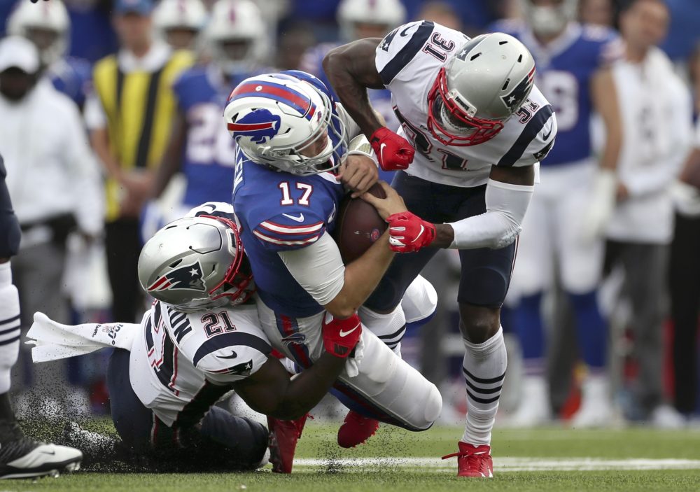 New England Patriots defenders Jonathan Jones (31) and Patriots Duron Harmon (21) tackle Buffalo Bills quarterback Josh Allen (17) in the second half of the game, Sept. 29, 2019. Allen left the field after the play. (Ron Schwane/AP)