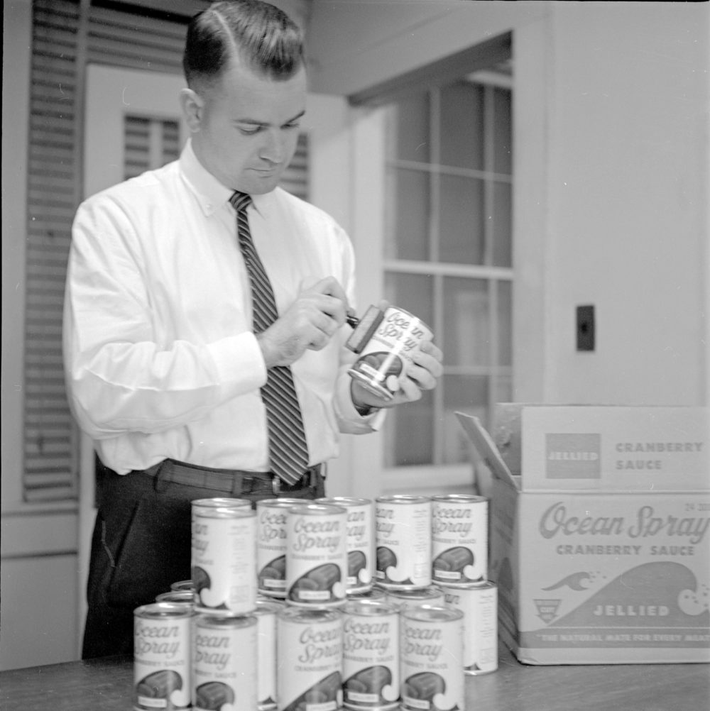 A man stamps cans of Ocean Spray cranberry sauce in December 1959. (The Daily Reflector/Courtesy of Joyner Library)
