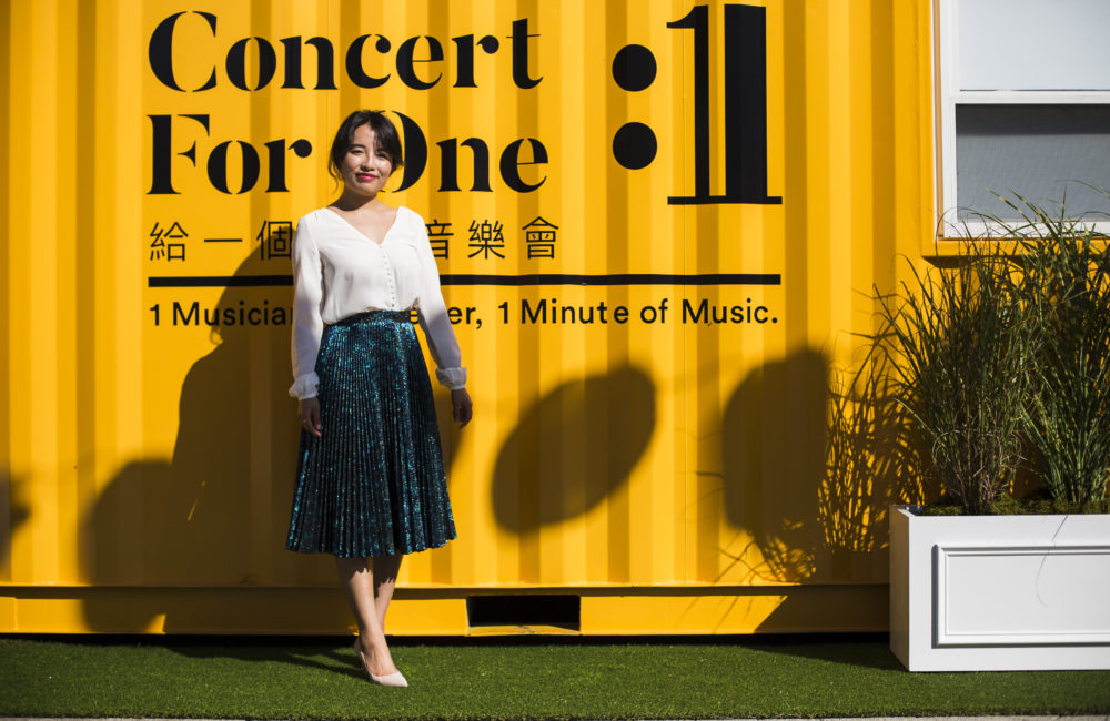 New England Conservatory graduate Rayna Yun Chou stands in front of shipping containers outfitted for her project, &quot;Concert for One.&quot; (Erin Clark for WBUR)