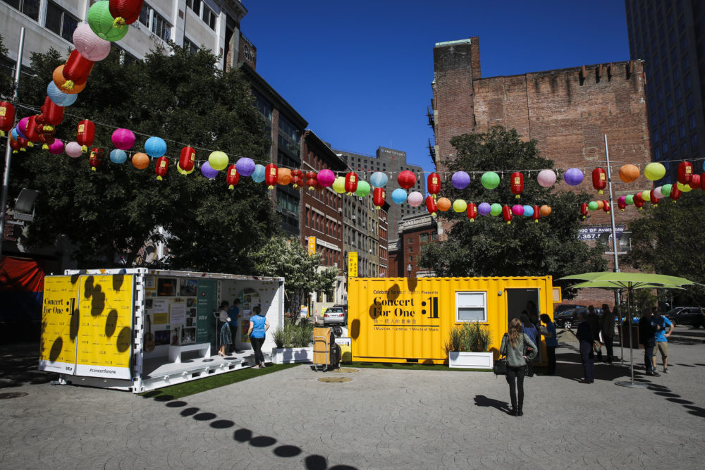 Yellow shipping containers set up in the middle of Chinatown. (Erin Clark for WBUR)