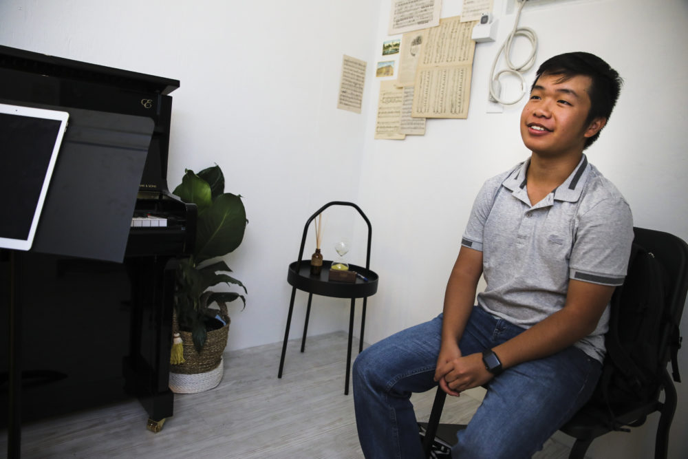 Eric Chan listens to Jean Huang perform during a &quot;Concert for One&quot; in Chinatown. (Erin Clark for WBUR)