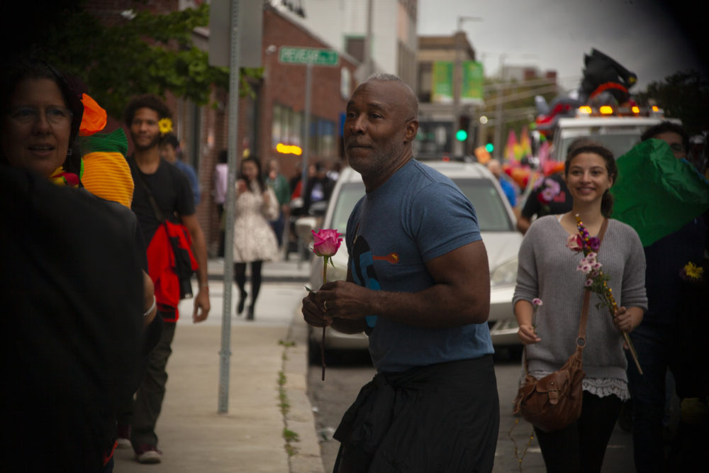 Nick Cave handing out roses to people passing by. (OJ Slaughter for WBUR)