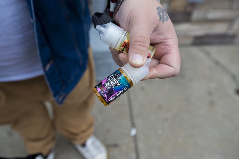 Dennis Yebba made the trip up to Salem, N.H., and holds three bottles of vaping juice just purchased at Smoker Choice including the cotton candy flavored Pink Squares Ejuice by Candy King. (Jesse Costa/WBUR)