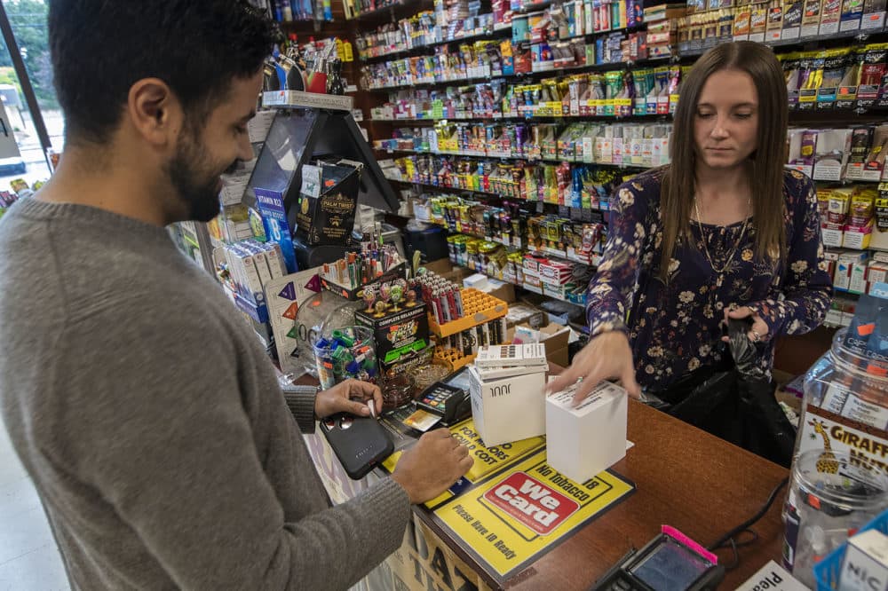 Israel Rolon, of Boston, purchases enough Juul pods to last four months, or until the temporary vaping ban is over, at Smoker Choice in Salem, N.H. (Jesse Costa/WBUR)
