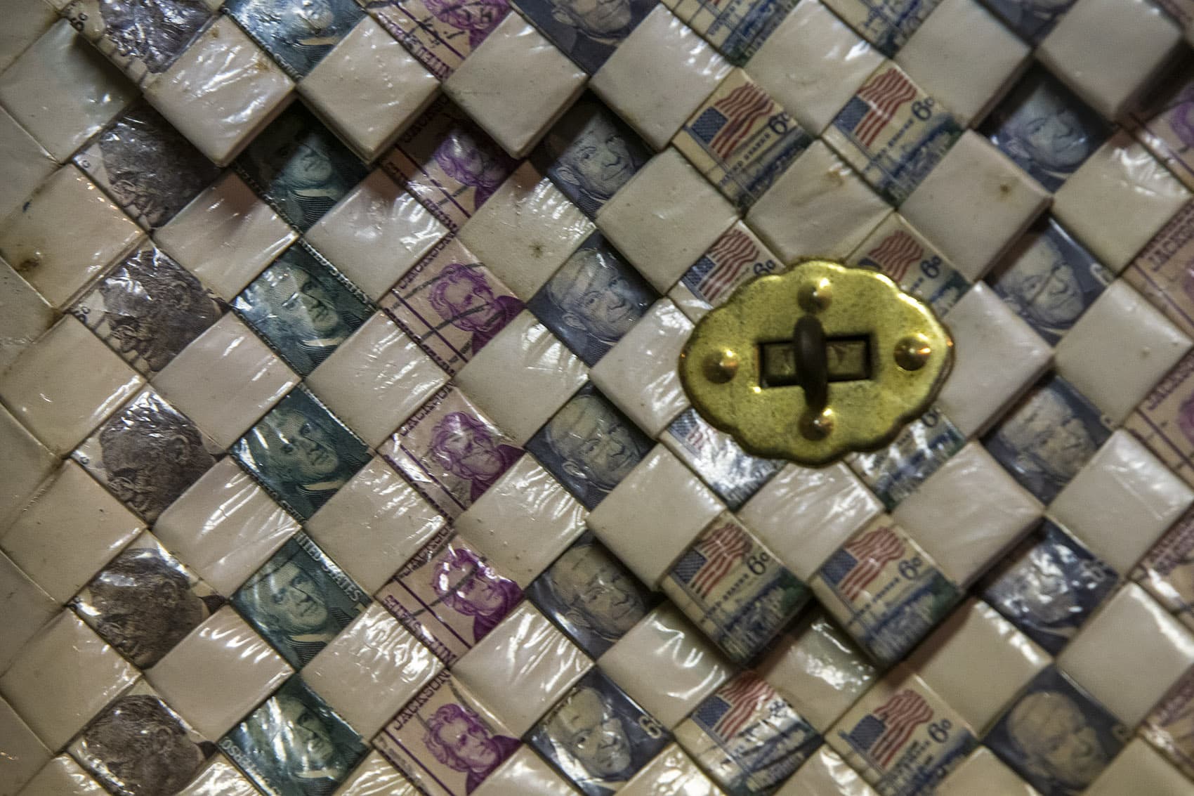 Detail of "Presidential Pardon," 1968, purse made of woven cigarette packaging and stamps of U.S. presidents Washington, Jefferson, FDR, and Eisenhower. (Jesse Costa/WBUR)