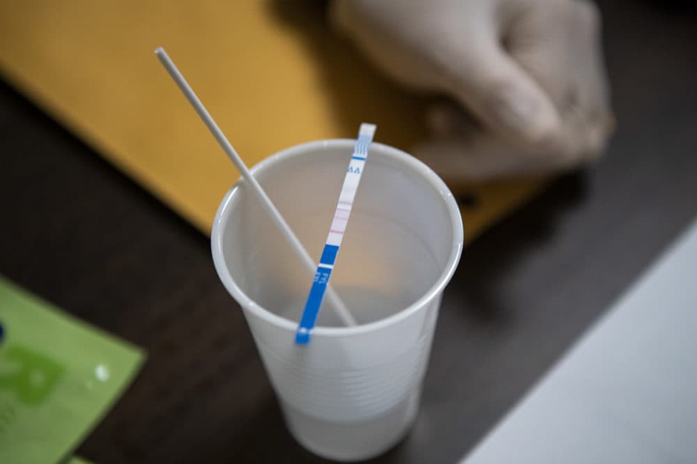 A fentanyl test strip is used to detect fentanyl in a drug sample. (Jesse Costa/WBUR)