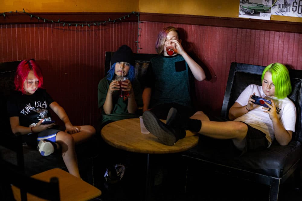 Matt Hiltz, Lincoln Zinzola, Dylan Huther and Nate Dalbec relax at The Midway Cafe. (OJ Slaughter for WBUR)