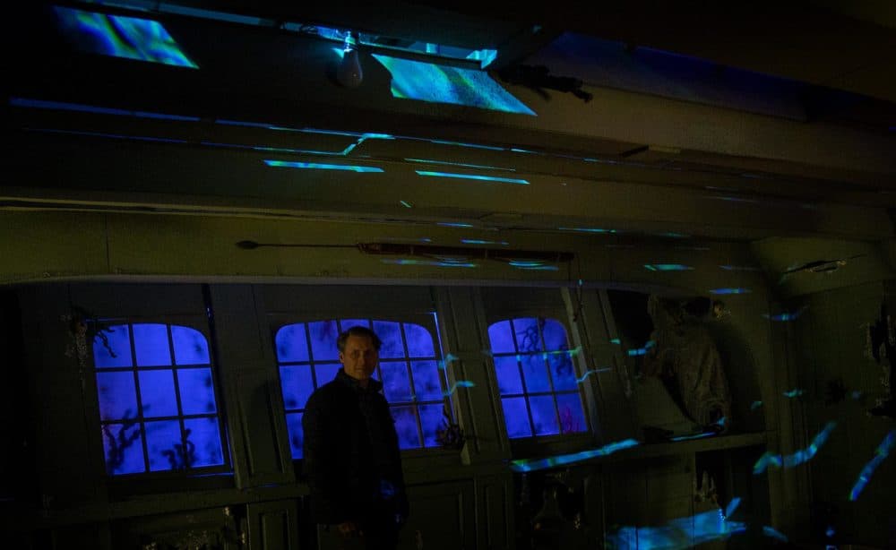 Thomas Saltsman stands inside the sunken ship. Through the windows visitors see the blue ocean. (Robin Lubbock/WBUR)