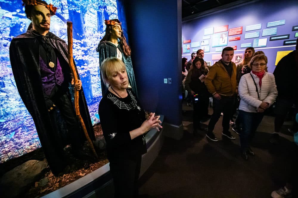 Jill Christiansen, assistant director of education at the Salem Witch Museum, leads a tour featuring depictions of witches throughout the centuries. (Jesse Costa/WBUR)