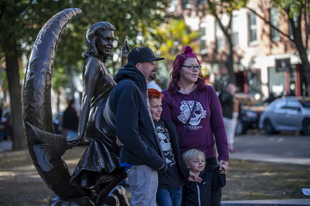 Visitors pose for photographs with the Bewitched sculpture. (Jesse Costa/WBUR)